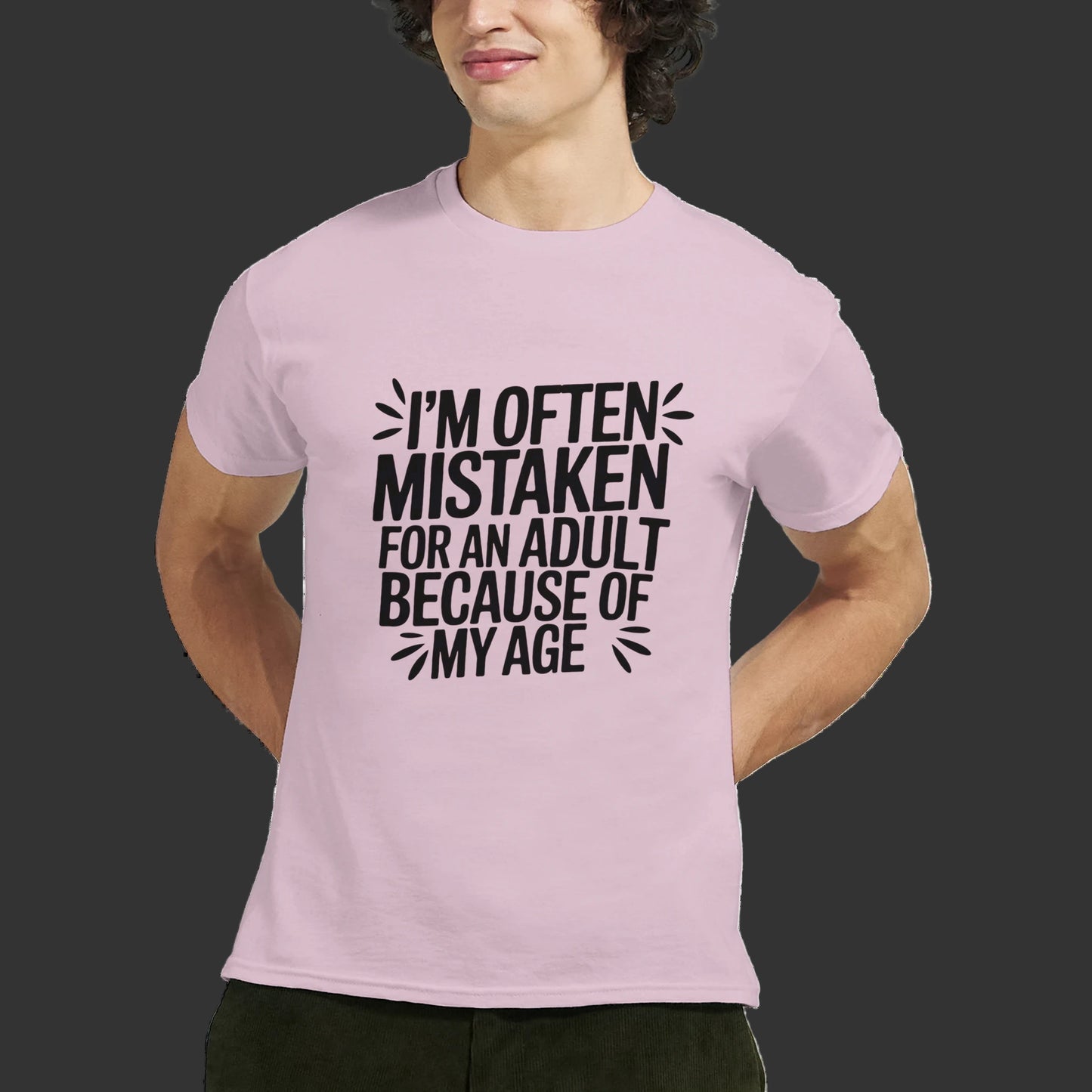 Person wearing a pink t-shirt that says "I'm often mistaken for an adult because of my age" design on a white background