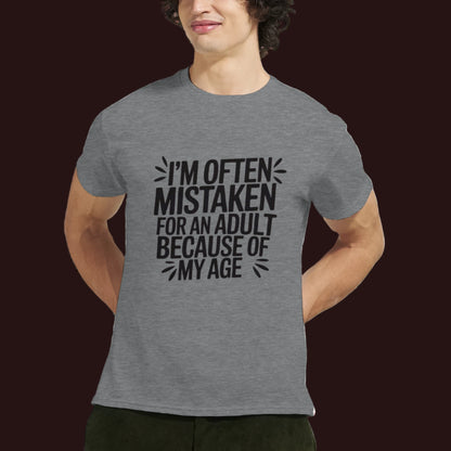 Person wearing a gray t-shirt that says "I'm often mistaken for an adult because of my age" on a white background