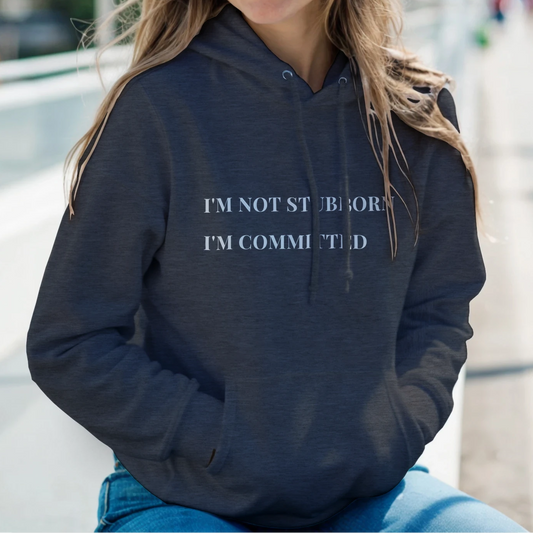 Unisex "I'm Not Stubborn, I'm Committed" hoodie worn by model, cozy fit with ribbed cuffs and kangaroo pocket, casual sweatshirt for funny sarcastic style