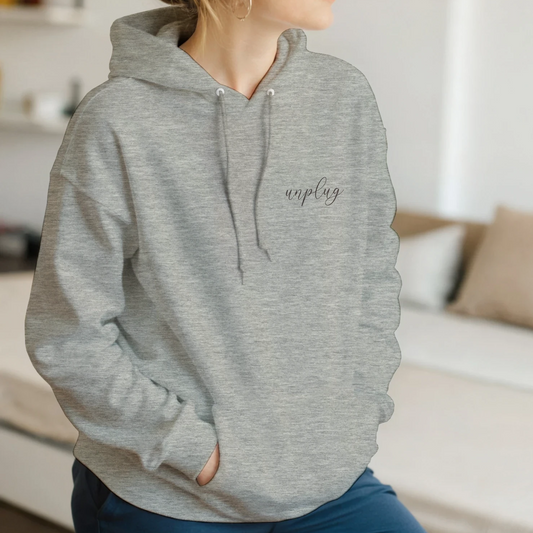 Unisex hoodie in Ash Heather with minimalist 'unplug' script in delicate Her Gianca font, soft cotton blend, front kangaroo pocket.